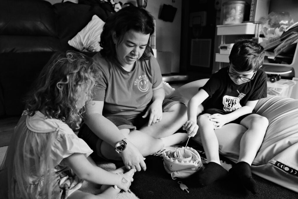 Mother, son and daughter playing a game in the living room